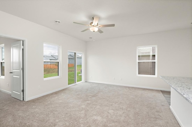 unfurnished living room with ceiling fan and carpet