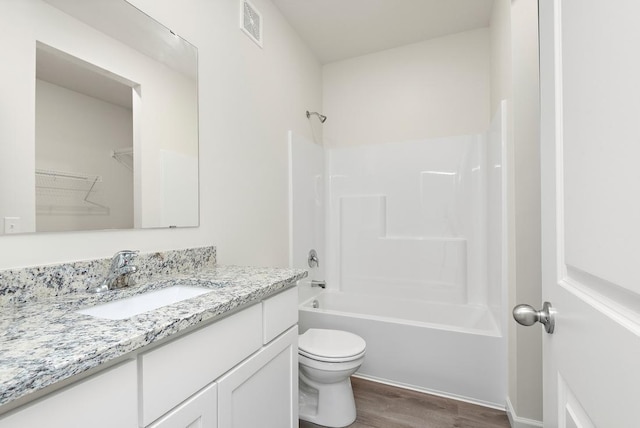 full bathroom with wood-type flooring, toilet, shower / washtub combination, and vanity