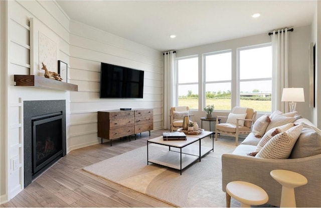 living room featuring wooden walls and light hardwood / wood-style flooring