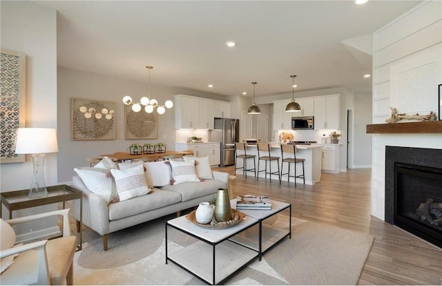 living room featuring a notable chandelier and light hardwood / wood-style flooring