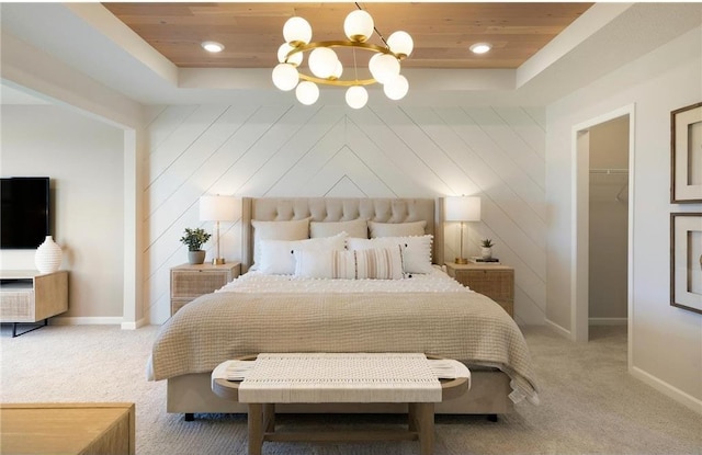 bedroom with carpet, wood ceiling, and a tray ceiling