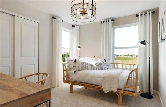 carpeted bedroom with an inviting chandelier