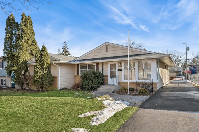 bungalow-style home featuring aphalt driveway and a front lawn