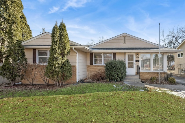 view of front of home with brick siding and a front yard