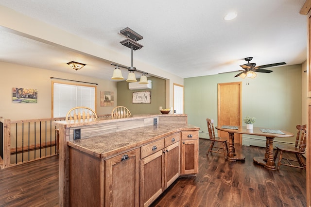 kitchen with pendant lighting, dark wood-type flooring, a textured ceiling, and a kitchen island