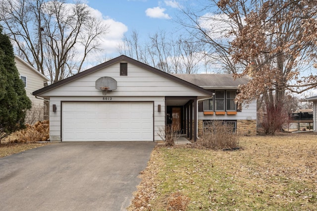 ranch-style home with a garage and aphalt driveway