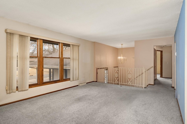 carpeted empty room featuring visible vents, a notable chandelier, and baseboards