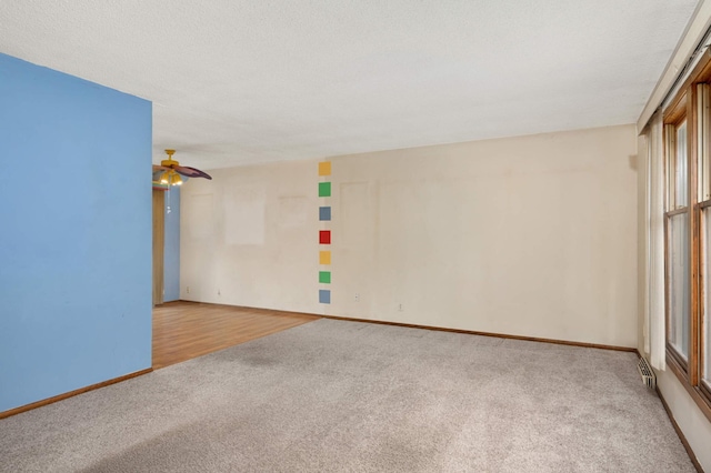 unfurnished room featuring light carpet, visible vents, baseboards, ceiling fan, and a textured ceiling