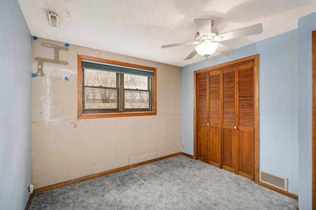 unfurnished bedroom with a closet, visible vents, a textured ceiling, and carpet flooring