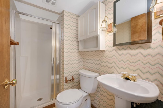 bathroom with visible vents, a sink, a shower stall, and toilet