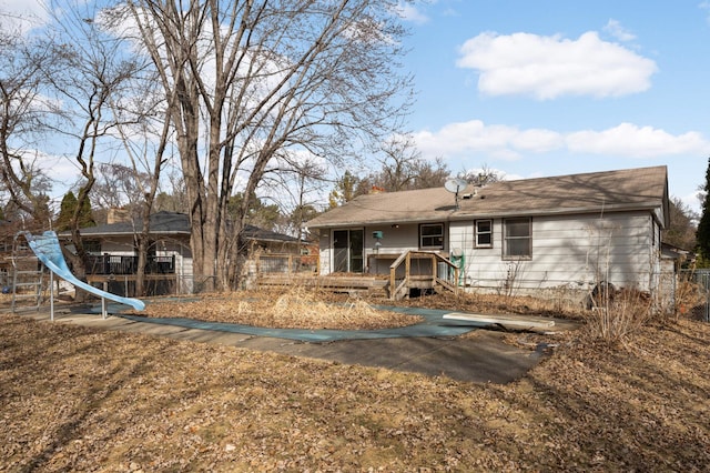 rear view of house with fence and a wooden deck