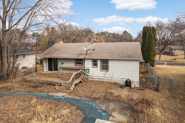 back of house with a fenced in pool, fence, a chimney, and a deck