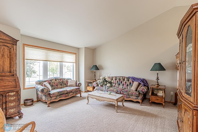 living room featuring lofted ceiling, light carpet, and baseboards