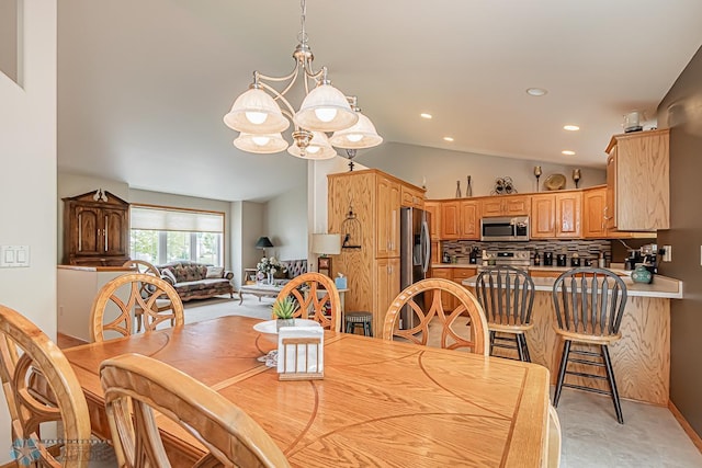 dining area featuring a chandelier, recessed lighting, and vaulted ceiling