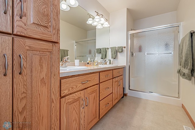 full bathroom with double vanity, a stall shower, and a sink