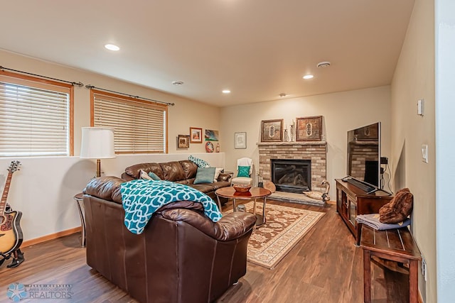 living area featuring a fireplace, baseboards, wood finished floors, and recessed lighting