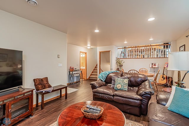 living area with recessed lighting, visible vents, dark wood-type flooring, baseboards, and stairs