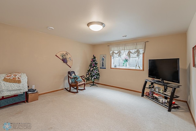 sitting room featuring carpet and baseboards