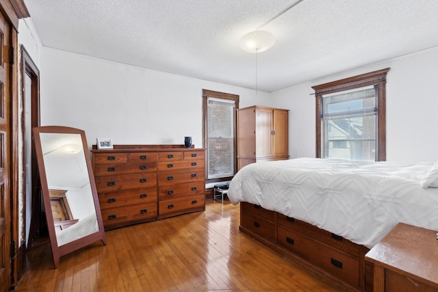 bedroom featuring a textured ceiling and light hardwood / wood-style flooring