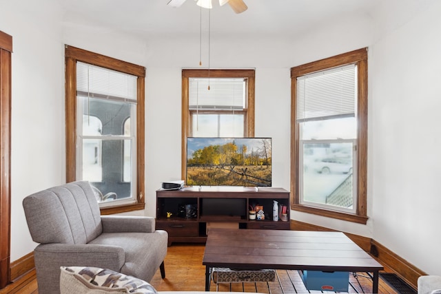 sitting room featuring a ceiling fan, wood finished floors, and baseboards