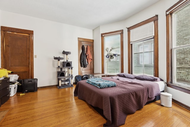 bedroom with a closet, baseboards, and light wood-style floors