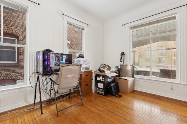 office space with a healthy amount of sunlight and hardwood / wood-style flooring