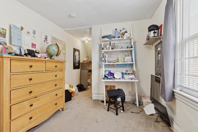 office area featuring baseboards and light carpet