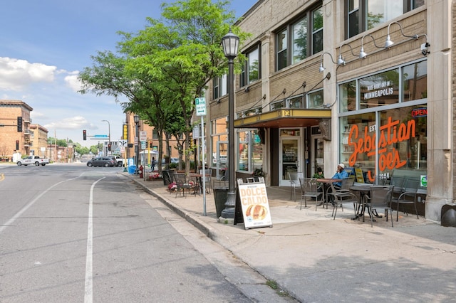 view of street featuring street lights, curbs, and sidewalks