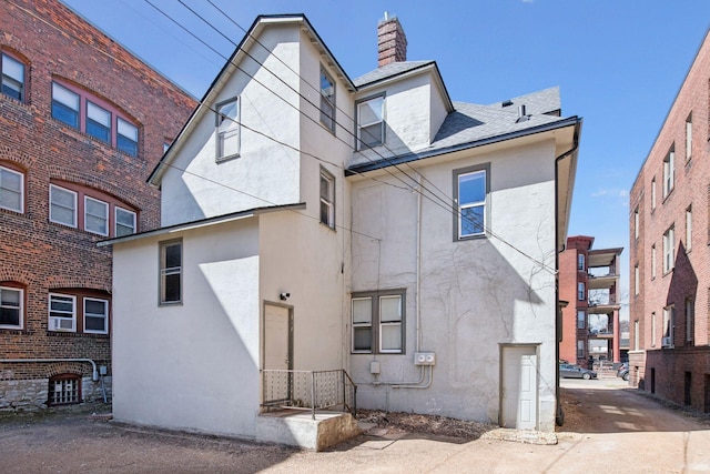 back of property featuring stucco siding and a chimney