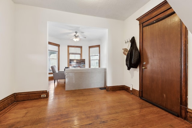 entrance foyer featuring visible vents, baseboards, ceiling fan, hardwood / wood-style flooring, and a textured ceiling