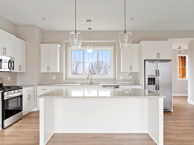 kitchen with white cabinetry, a kitchen island, and appliances with stainless steel finishes