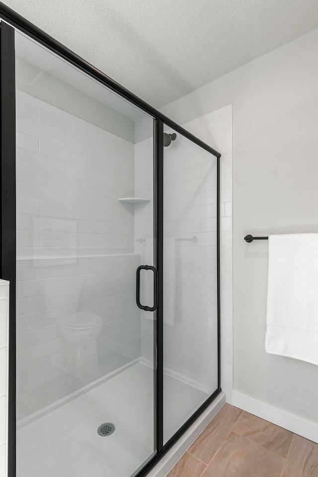 932 Orchard Ln, Roseville, MN 55113 - bathroom featuring a shower stall and a textured ceiling