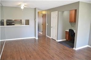 unfurnished living room featuring baseboards and wood finished floors