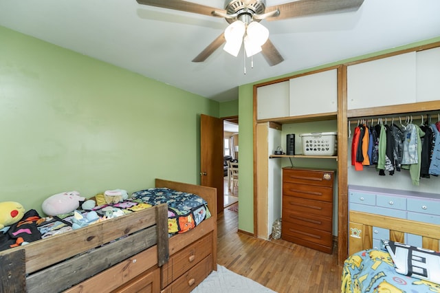 bedroom featuring two closets, ceiling fan, and light hardwood / wood-style flooring