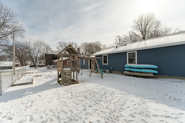 snow covered house with a playground