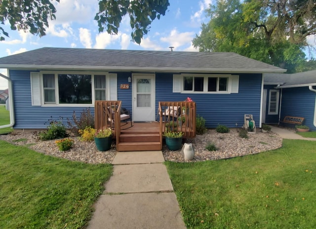 ranch-style home with a deck and a front lawn