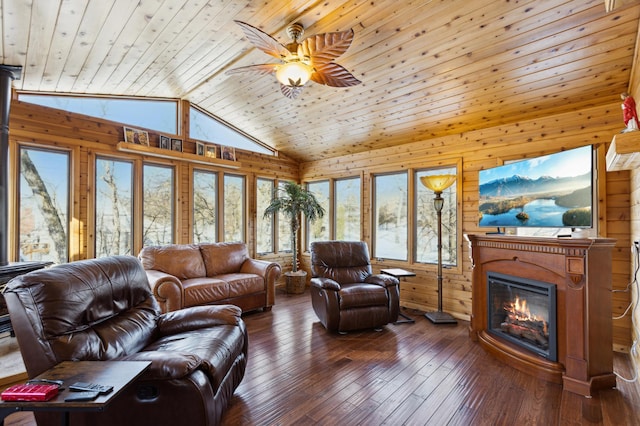 living room with wooden walls, dark wood-type flooring, ceiling fan, high vaulted ceiling, and wooden ceiling