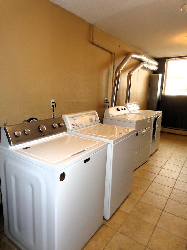 clothes washing area with separate washer and dryer and light tile patterned floors