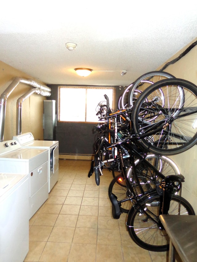 washroom featuring independent washer and dryer, a textured ceiling, and light tile patterned floors