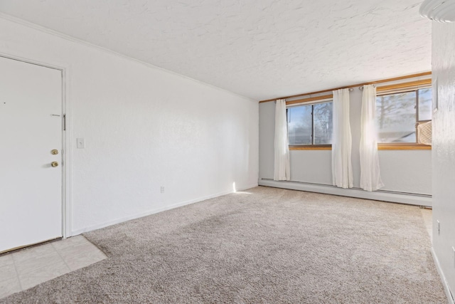 carpeted spare room with a baseboard radiator and a textured ceiling