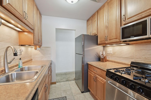 kitchen featuring stainless steel appliances, sink, and backsplash