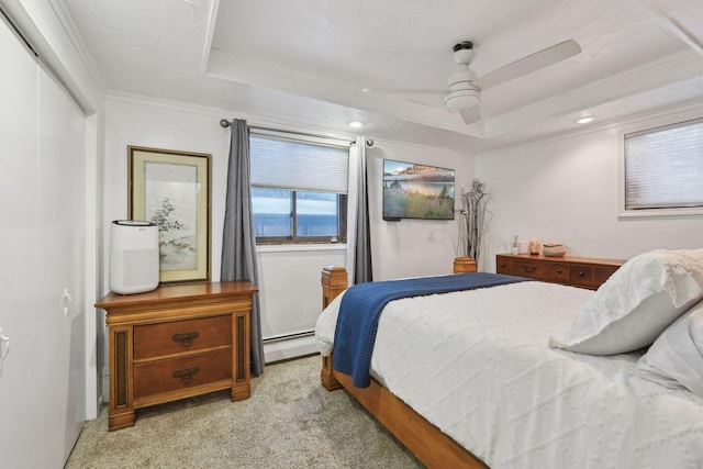 bedroom featuring light carpet, a closet, a tray ceiling, and crown molding