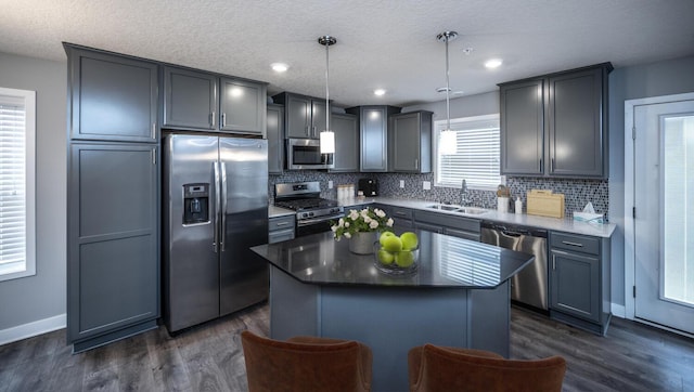 kitchen featuring a sink, dark wood finished floors, backsplash, and stainless steel appliances