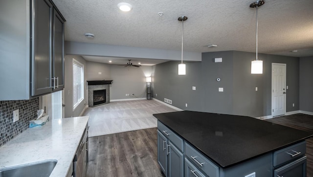 kitchen with tasteful backsplash, visible vents, ceiling fan, open floor plan, and a fireplace