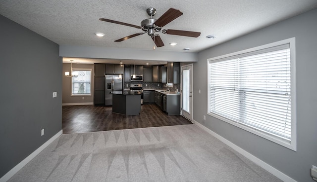 kitchen featuring a kitchen island, backsplash, stainless steel appliances, and baseboards