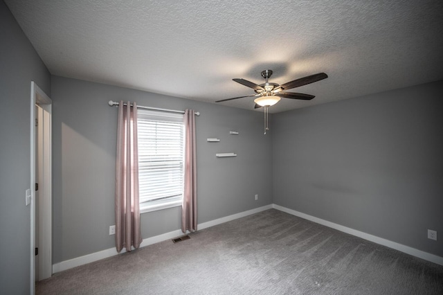 empty room with visible vents, baseboards, ceiling fan, carpet flooring, and a textured ceiling