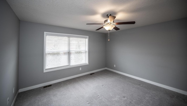 unfurnished room featuring visible vents, carpet floors, a textured ceiling, and baseboards