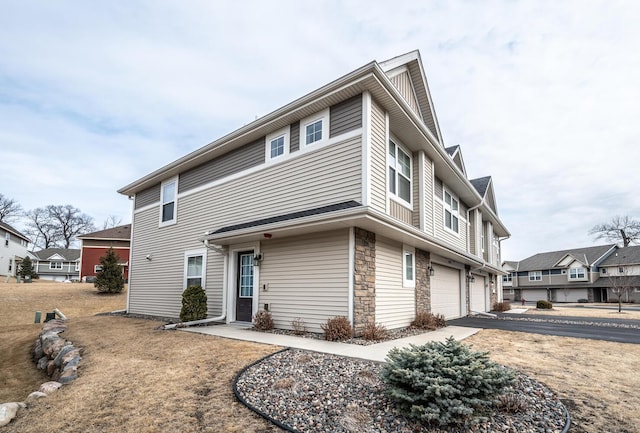 view of front facade with a garage, stone siding, and driveway