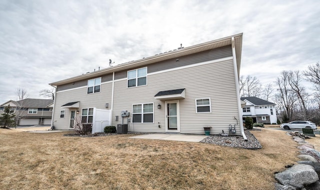 back of house with a lawn, central AC unit, and a patio area