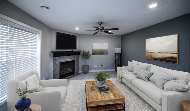 living room featuring visible vents, a fireplace with flush hearth, recessed lighting, baseboards, and ceiling fan